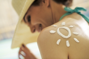 Woman tanning at the beach with sunscreen cream