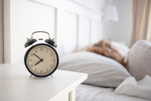 alarm clock and woman sleeping in bed sleep quality