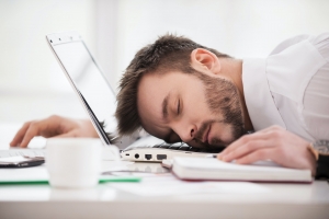 Sleeping at working place. Young man in formalwear sleeping at the working place